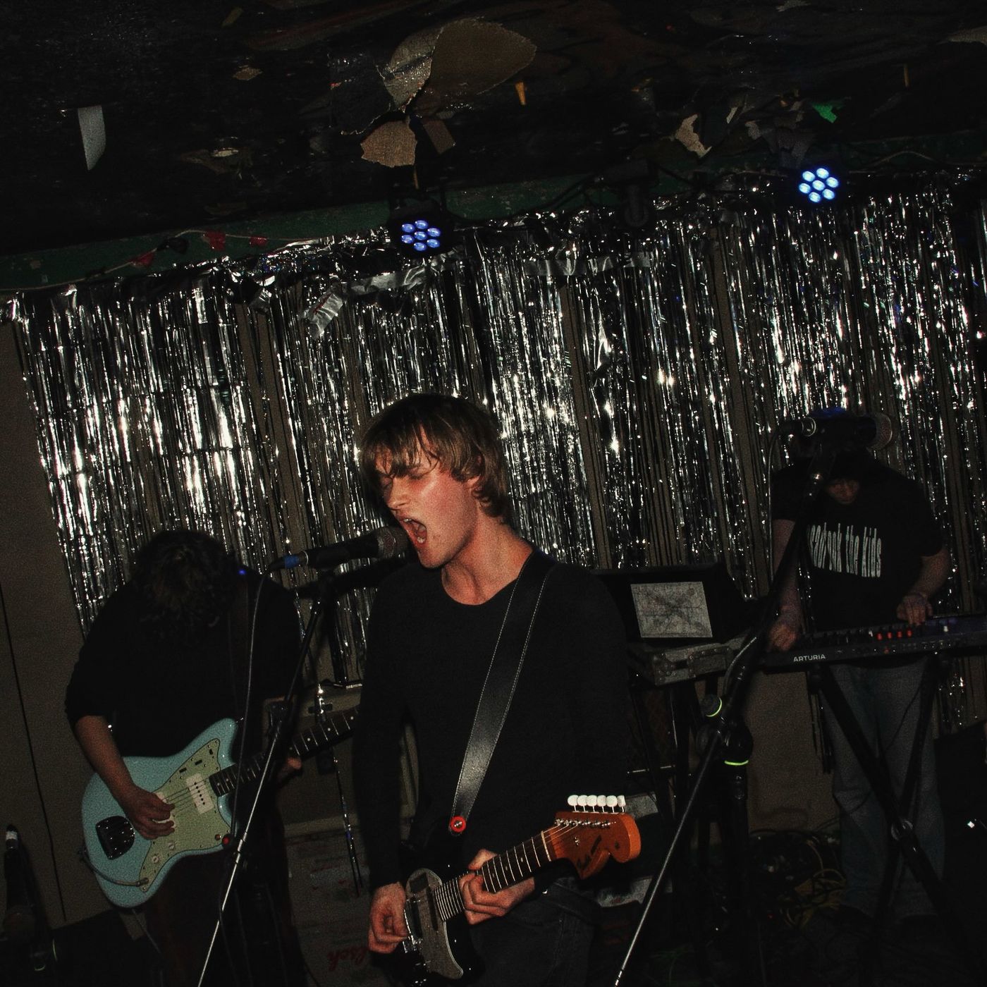 A singer mid-shout with his guitar