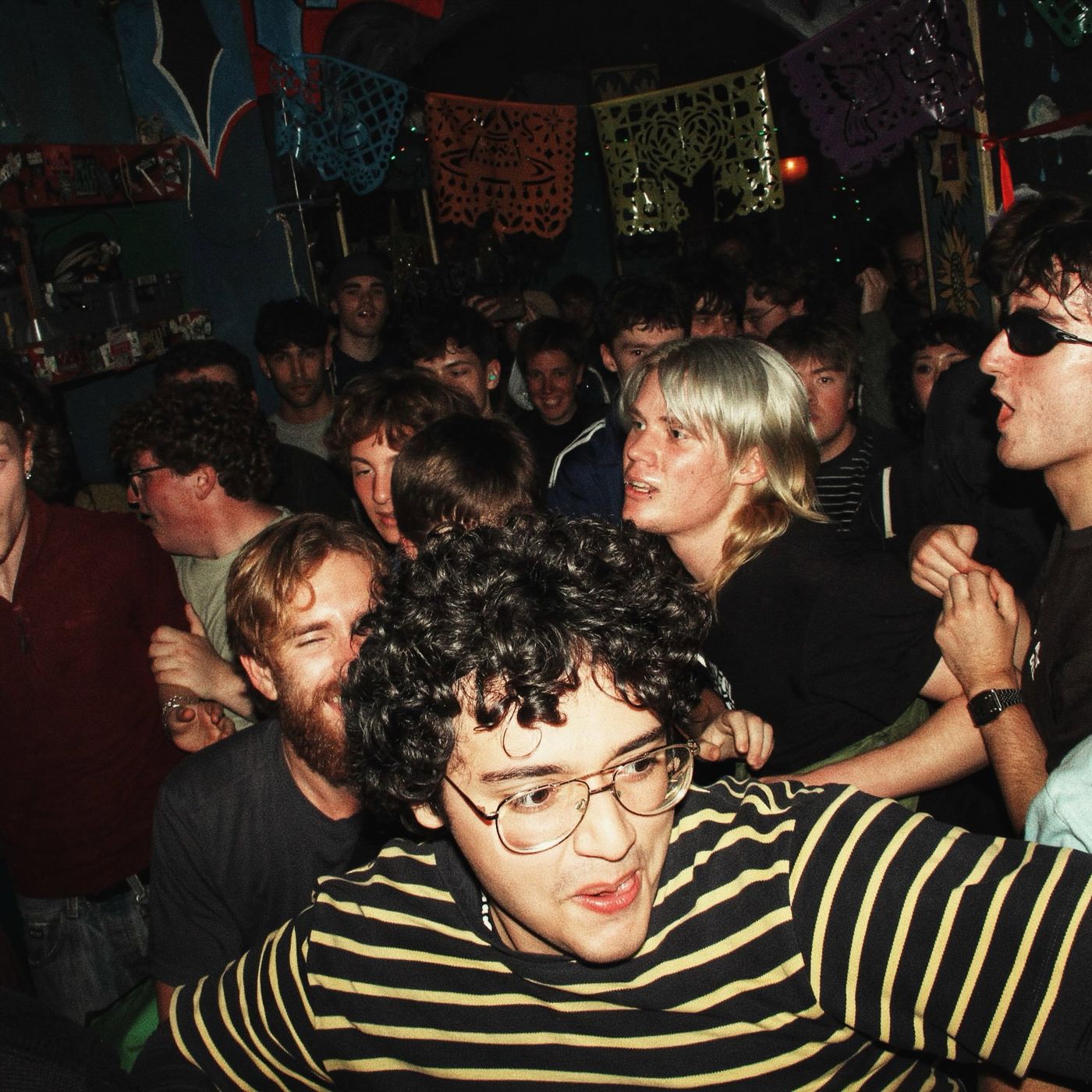 A grinning fan in a striped top in the middle of the crowd
