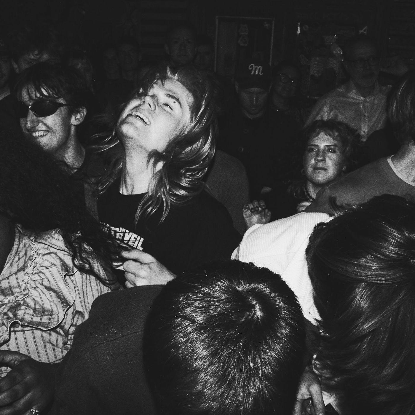 Black-and-white photo of a fan with her head thrown back in the crowd