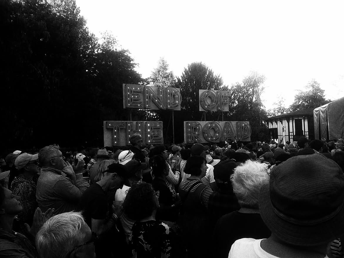 The lit-up End of the Road sign above the crowd